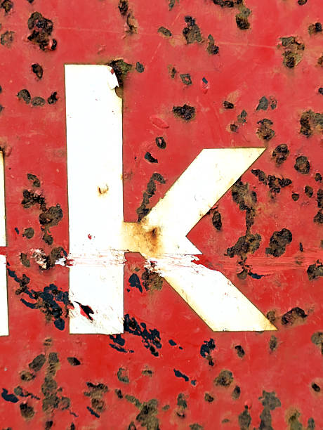 A macro photograph showcasing the intricate patterns of cracked and peeling paint on a surface. The image features a stark contrast between red and white stripes, with the white areas exhibiting extensive cracking and flaking. The texture is highly detailed, revealing the layered nature of the paint and the underlying surface. The composition emphasizes the abstract quality of the deteriorating paint, creating an intriguing visual study of decay and texture.