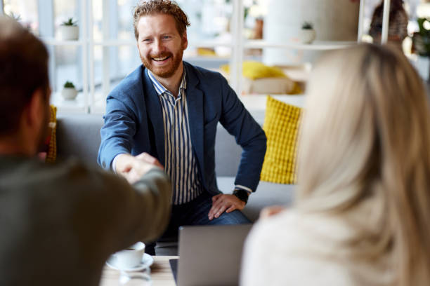 istock Happy insurance agent shaking hands with his customers in the office. 2197388332