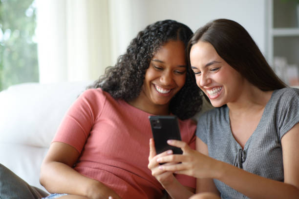 istock Happy interracial roommates using cell phone at home 2197388346