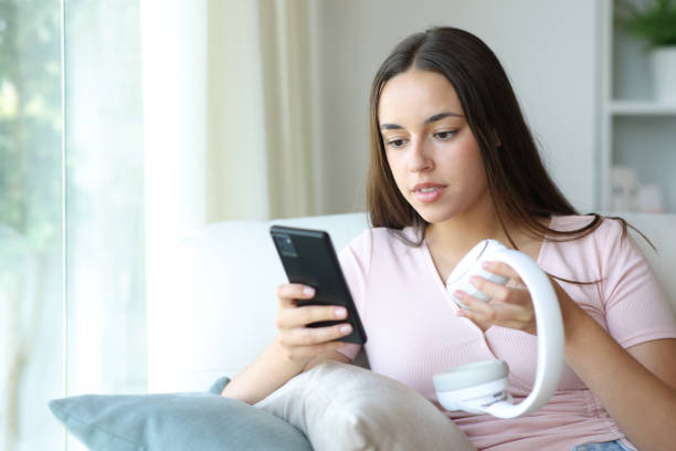 istock Woman pairing wireless headphone with her smart phone 2197388867
