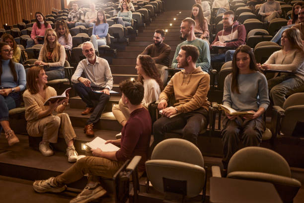 istock Happy senior professor talking to his students during a casual class at lecture hall. 2197390492