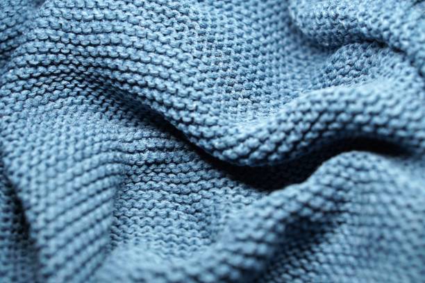 istock blue background with soft, textured wool knitted fabric texture, with pleats and volume 2197391257