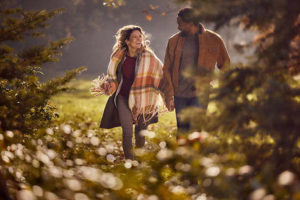 istock Cheerful diverse couple having fun while running during autumn in nature. 2197391627