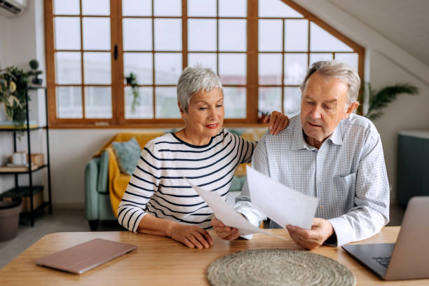 istock Senior couple going over bills at home together 2197394306