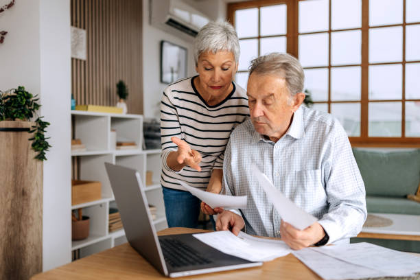istock Senior couple examining bills at home 2197394522