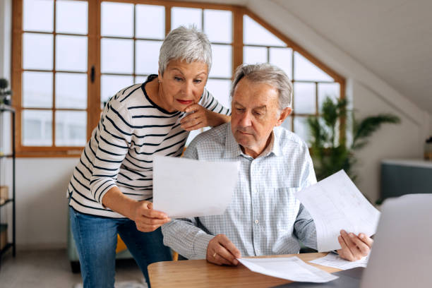 istock Senior couple examining bills at home 2197394549
