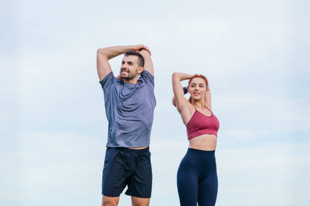 istock Fit Couple Stretching Arms Outdoors Before Workout 2197394793