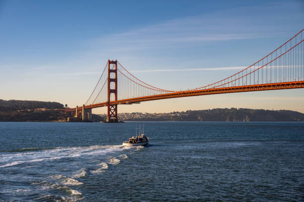 The iconic Golden Gate Bridge in San Francisco, California, with a boat cruising through the bay. This stunning view captures the world-famous suspension bridge, deep blue waters, and the beauty of the city’s coastline.