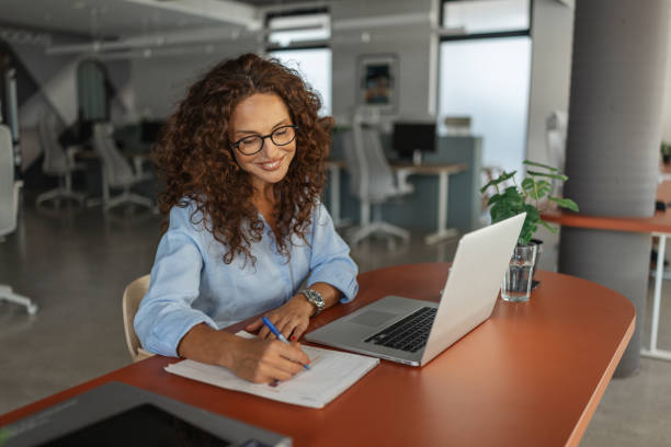istock Professional woman writing notes in modern office 2197402566