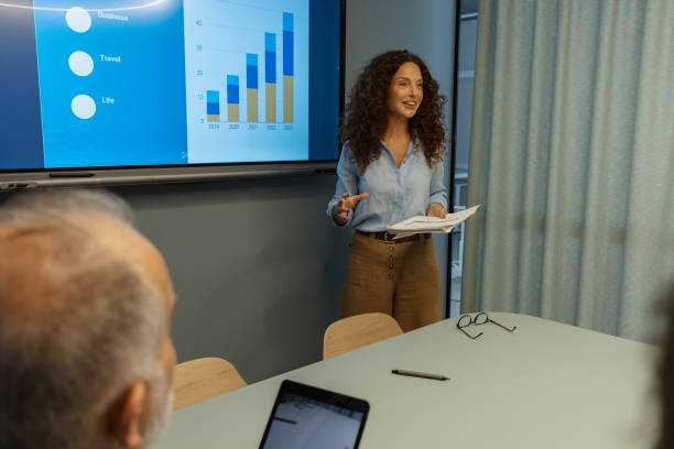 istock Woman in meeting discusses business statistics chart. 2197403152