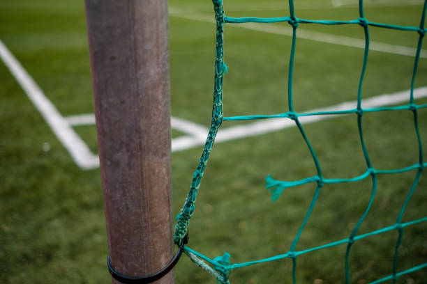 Soccer (football) field through the green net, with the net in focus