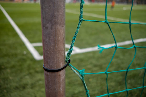Soccer (football) field through the green net, with the net in focus