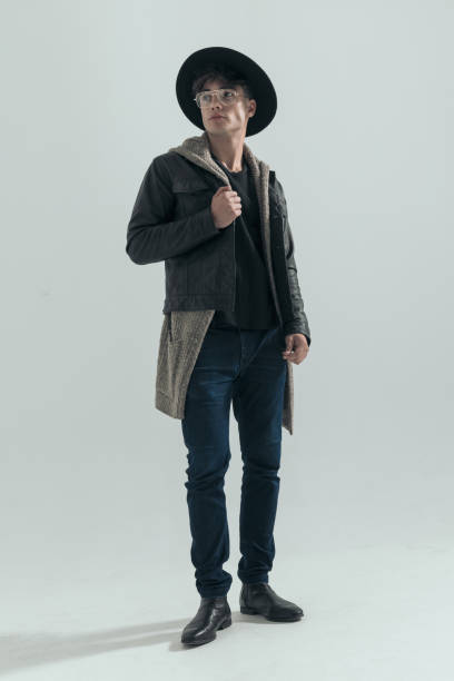 istock sexy young man in his 20s with hat and glasses adjusting jacket 2197403367