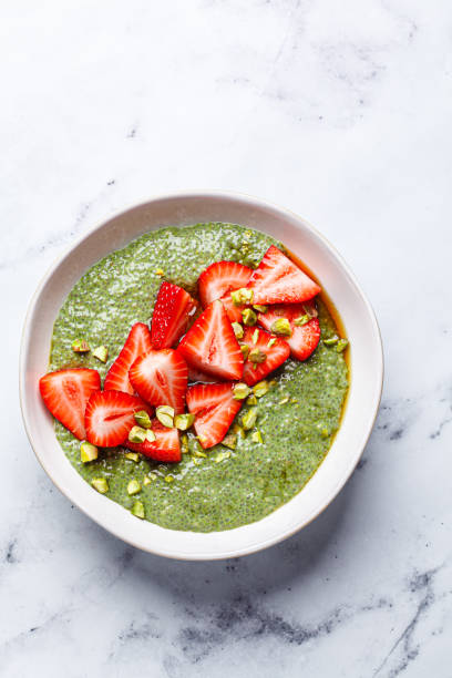 Green matcha chia pudding with strawberries and pistachios.