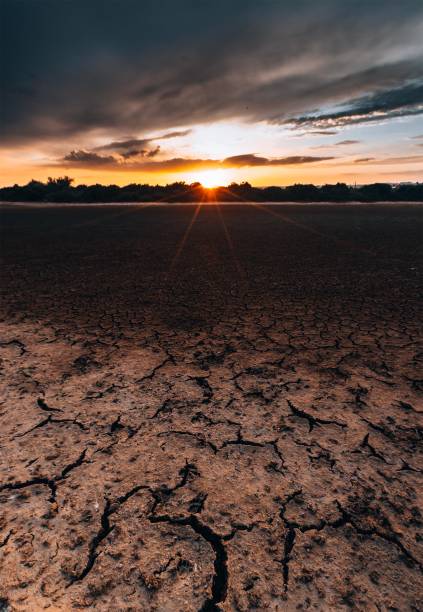 istock Dry, cracked ground under a colorful evening sky 2197405851