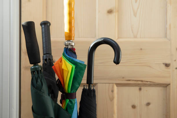 istock Four umbrellas by a wooden door 2197411137