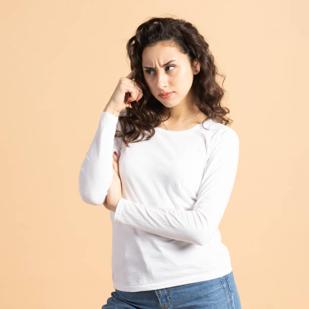 istock Thoughtful woman portrait on beige background 2197415483