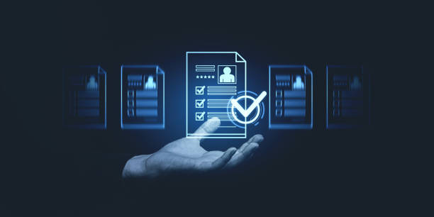 istock Digital hand holding a glowing document with checkmarks in a futuristic interface on a dark background for a recruitment or selection concept. 2197416208
