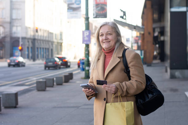 istock Senior woman texting on phone while walking outdoor 2197416242