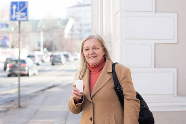 istock Mature woman with coffee walking 2197416658