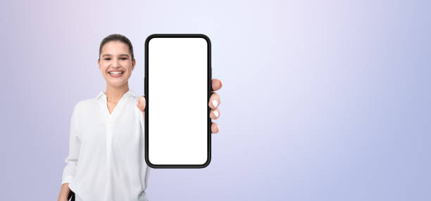 istock Smiling person holding a smartphone with blank screen, on a grad 2197416982