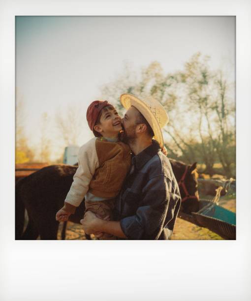 Photo of a little boy and his father sharing some precious moments at their horse ranch