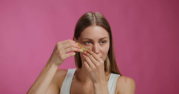 istock A woman applies patches under her eyes 2197418373
