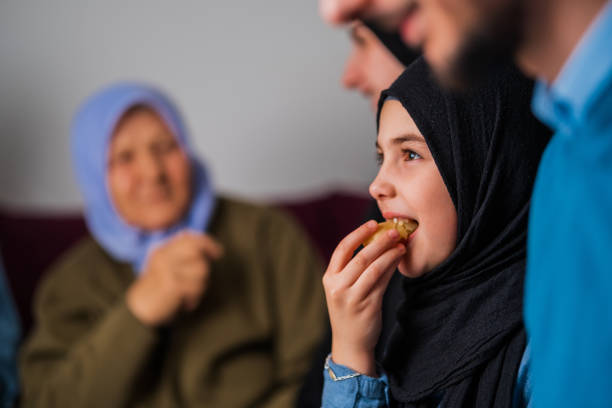 A happy mother and daughter sit together during lunch, sharing smiles and conversation. The scene highlights parental care, emotional connection, and a nurturing home environment.
