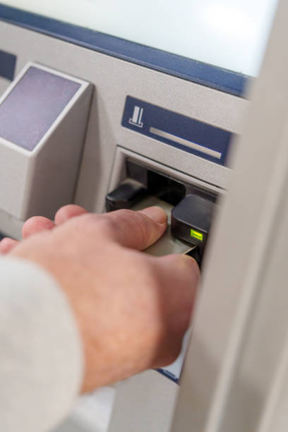 istock Businessman inserting credit card into atm 2197422273