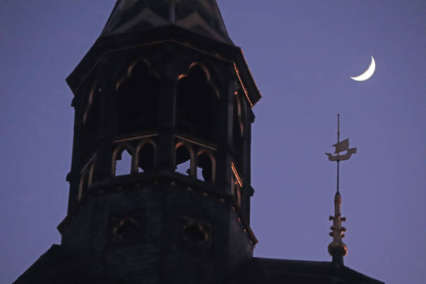 Silhouette of the old city of Kampen in Overijssel, The Netherlands with the New Tower and rooftops against a colorful orange sunset at the end of the day.