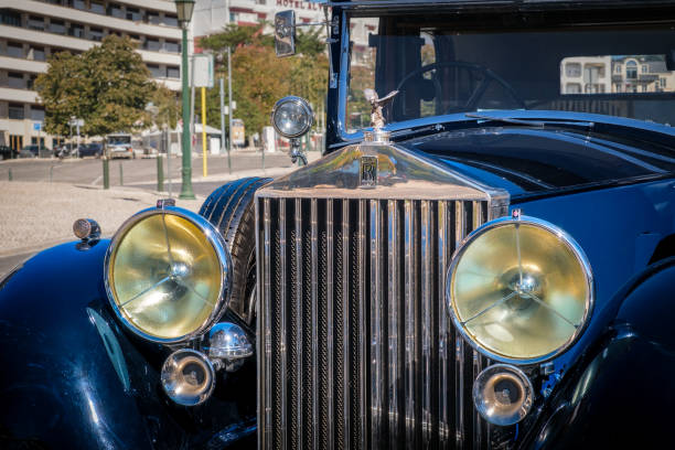Vintage Elegance: Detailed View of a Classic Car's Chrome Headlight and Iconic Grille - Preserving Automotive History