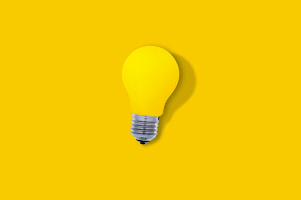 istock Yellow glass bulb with hard shadow, on yellow background, with copy space. Ideas and lighting concept 2197430533