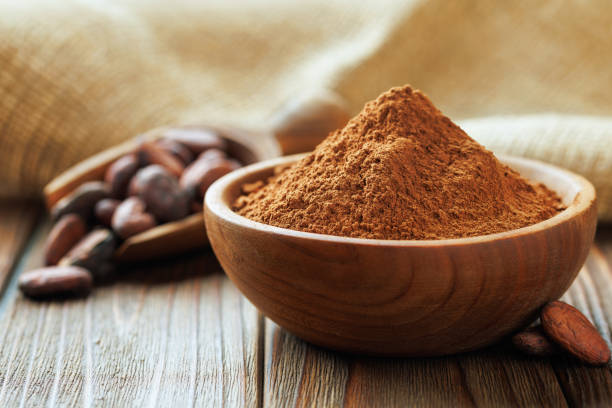 istock cocoa powder in bowl and cocoa beans in scoop on table 2197430635