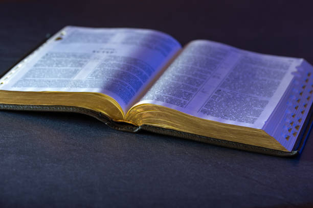 istock Open Holy Bible on the table. Religion concept. Bible on black background. 2197430982
