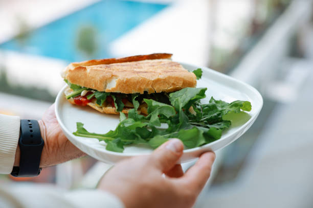 A male chef prepares a sausage and cheese sandwich. Traditional Turkish sandwich; kumru.
