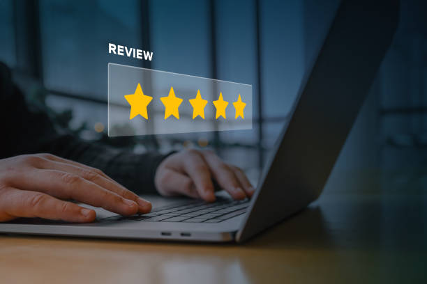 A person using a laptop with a digital overlay of a five-star rating and the word "review." Concept of customer feedback, online reputation, business rating, and digital marketing strategy A person using a laptop with a digital overlay of a five-star rating and the word "review." Concept of customer feedback, online reputation, business rating, and digital marketing strategy. product review stock pictures, royalty-free photos & images