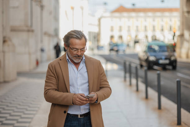 istock Confident elderly man texting on the city street. 2197433034