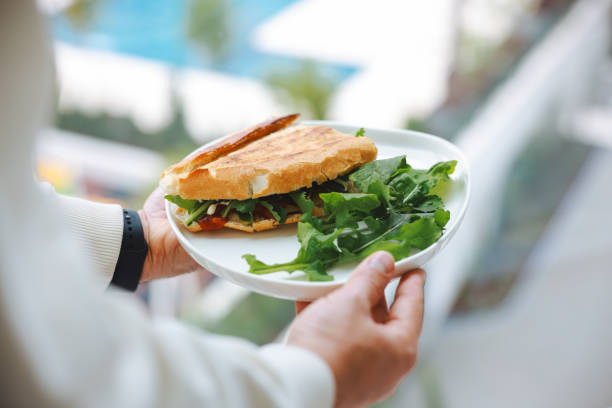 A male chef prepares a sausage and cheese sandwich. Traditional Turkish sandwich; kumru.