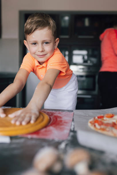 istock Happy cute little boy  preparing baking the dough in kitchen at home 2197434512