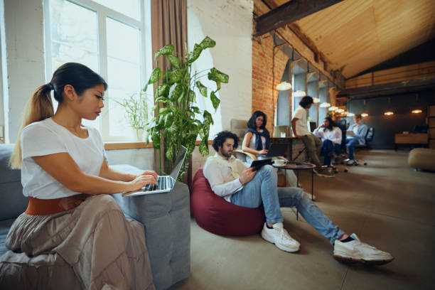 istock Young entrepreneurs and students in co-working space working and cooperating. Cozy, comfortable professional atmosphere 2197435088