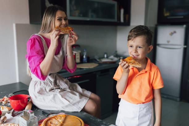 istock Mother and son making pizzas and eat 2197438272