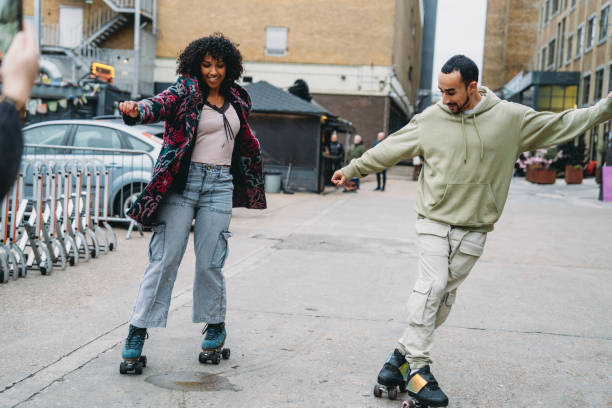 istock Young couple roller skating together in urban setting, enjoying roller disco revival 2197440054