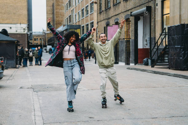 istock Happy couple roller skating and holding hands in London 2197440121