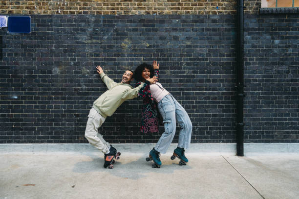 istock Young couple leaning against a wall with roller skates 2197440162