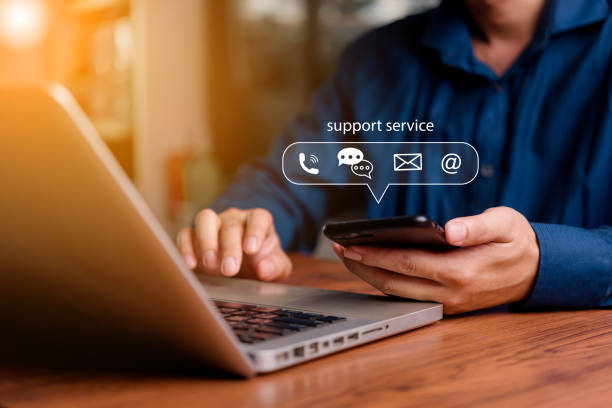 istock Customer support concept. Man using smartphone and laptop with virtual chat icons for email, phone, and AI chatbot assistance in business communication. 2197440304
