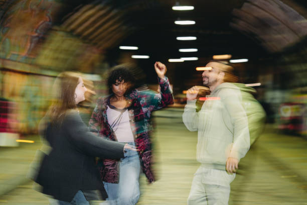 istock Young friends dancing together under a bridge at night 2197440406