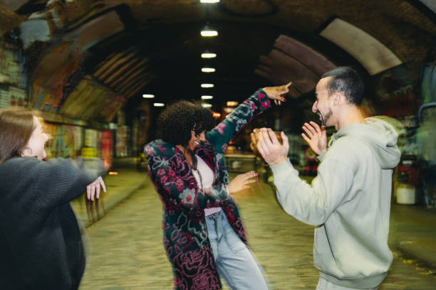 istock Young friends dancing under a bridge at night 2197440427