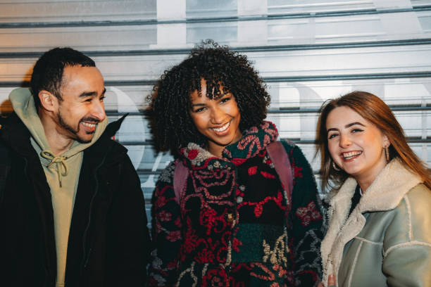 istock Three young adults smiling and looking at camera 2197440602