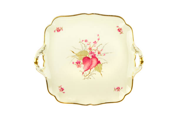 Vintage plate of unusual shape with gold rim isolated on white background.