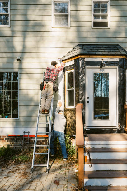 istock Construction workers repairing the siding of a house 2197444446